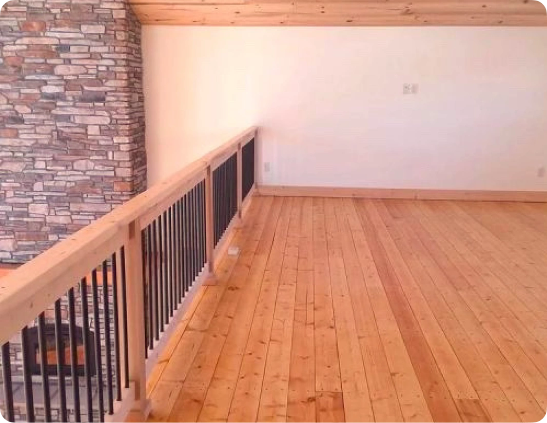 A room with wood floors and black railing.