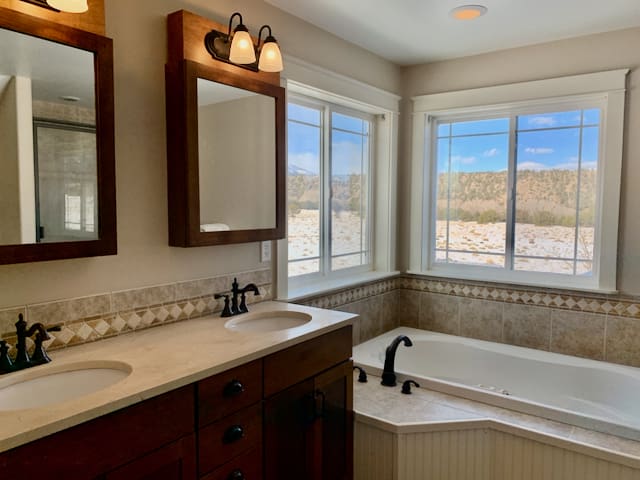 A bathroom with two sinks and a tub.