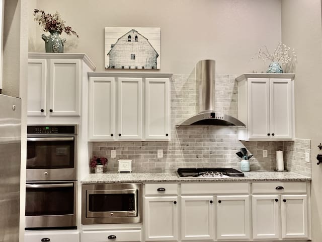 A kitchen with white cabinets and stainless steel appliances.