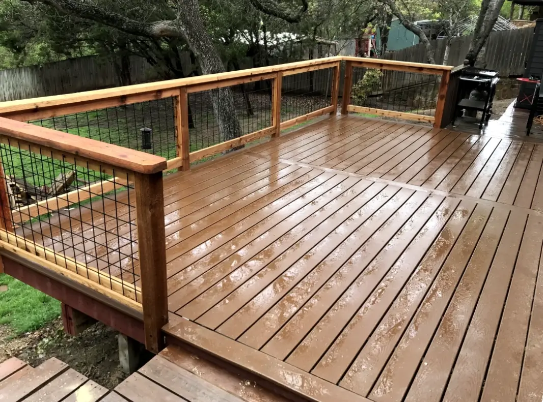 A wooden deck with wire railing on top of it.