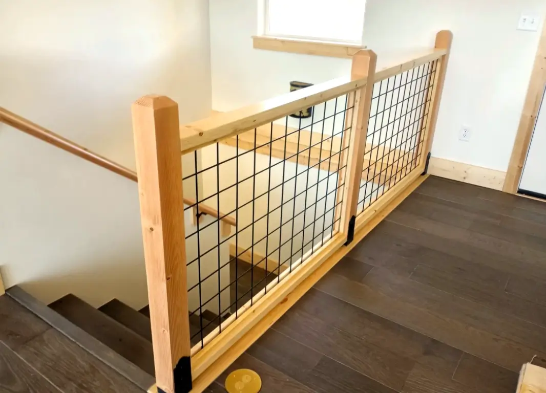 A wooden railing with metal bars on the side of it.