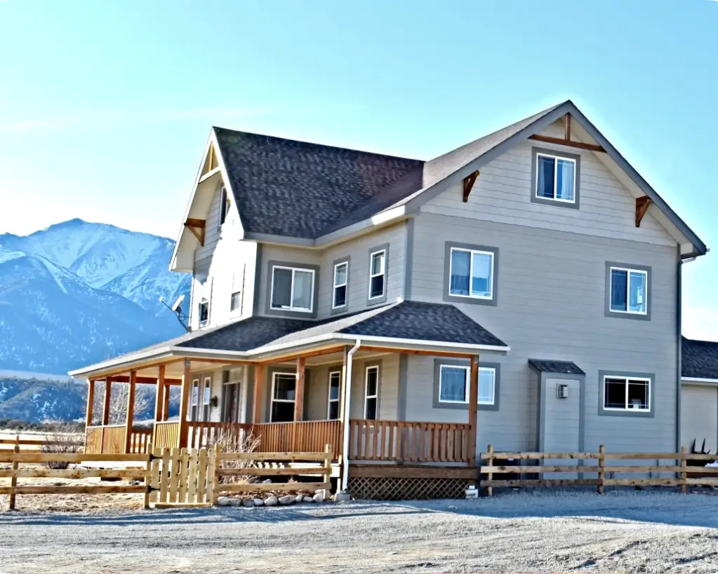 A large white house with a wooden deck.