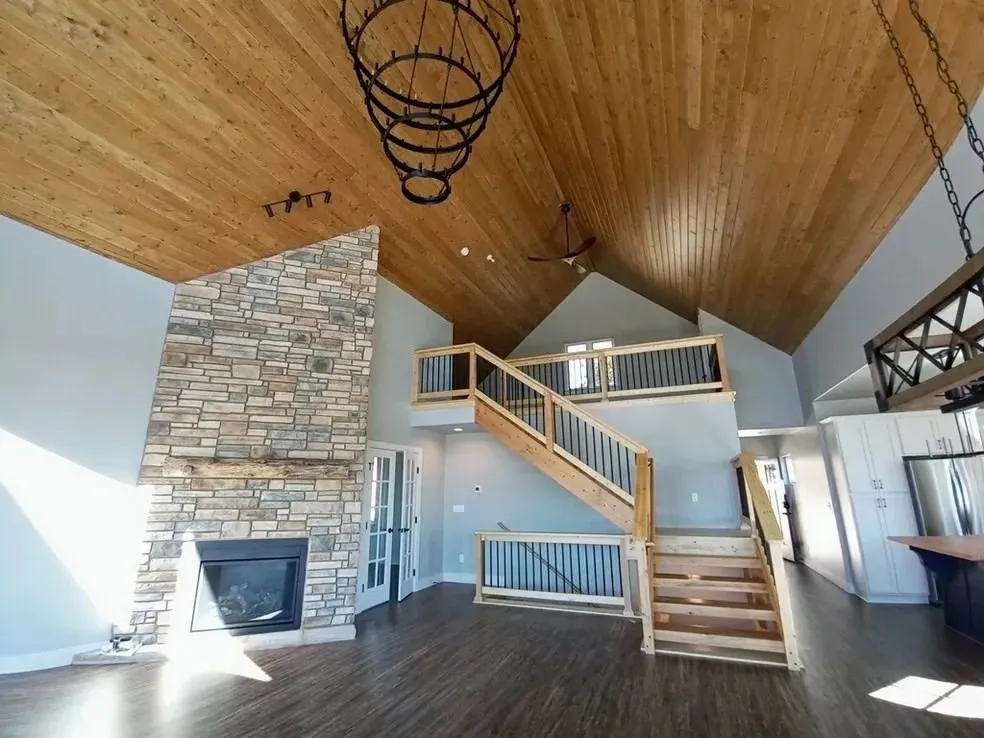 A large room with stairs and fireplace in it